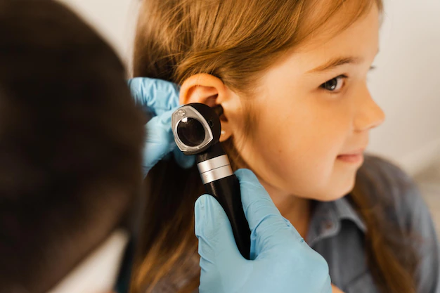 Close-up examination of a child's ear with an otoscope