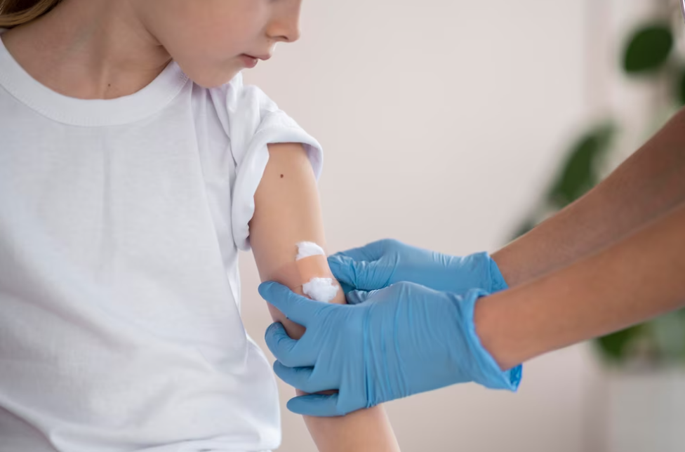 doctor holds a hand of little girl after vaccination, girls is watches on her arm