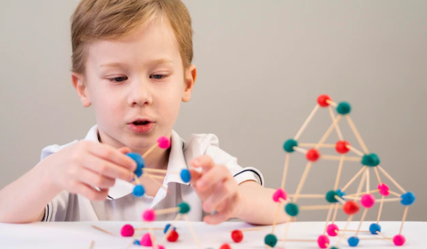 Boy playing with colorful atoms at home