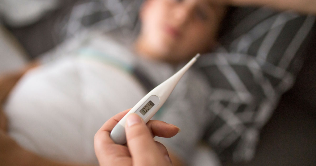 Hand holding a thermometer