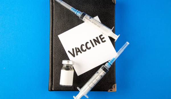 Top view antiviral injections with notebook and vaccine on blue surface