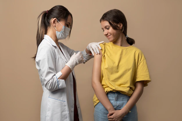 The doctor makes a vaccination to the girl